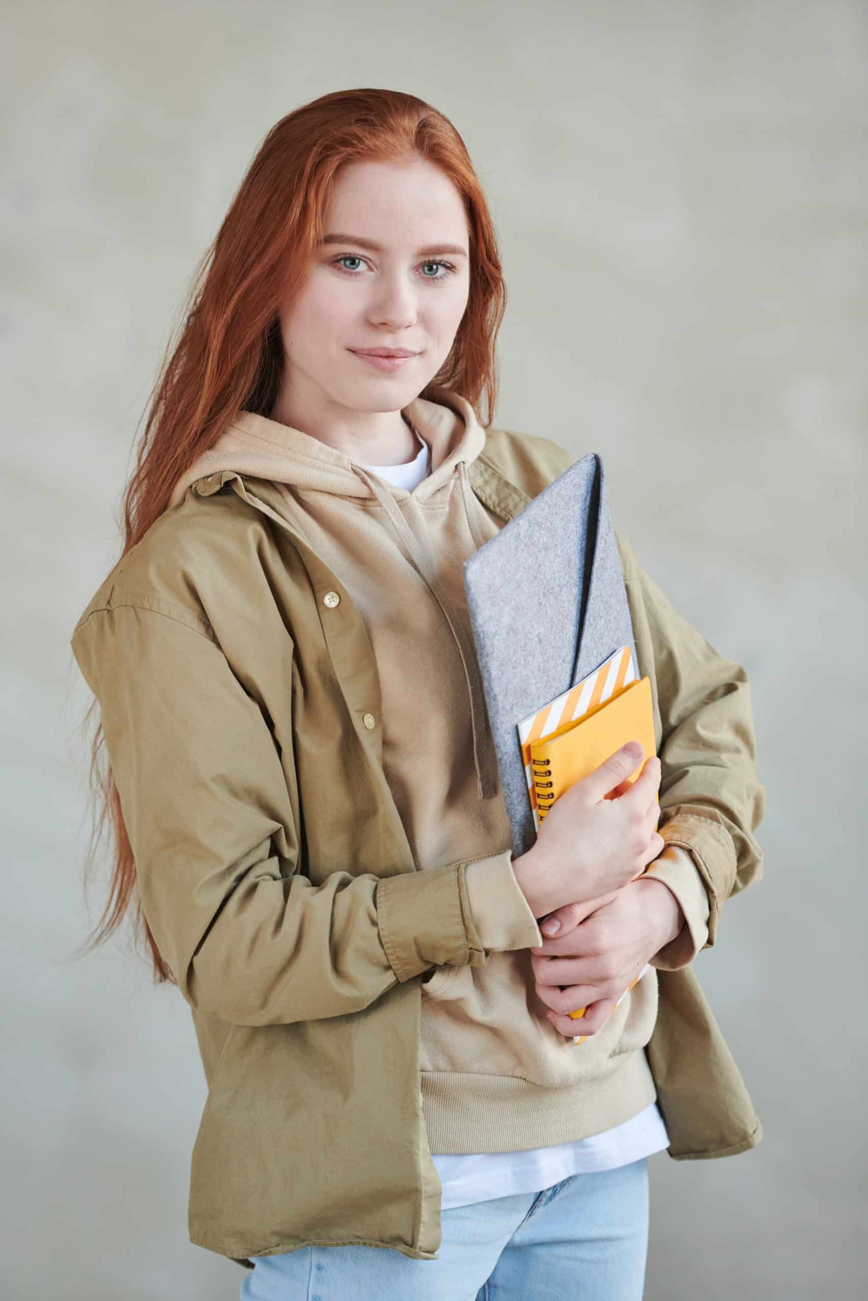 Student with red hair holding textbooks 1221245 scaled