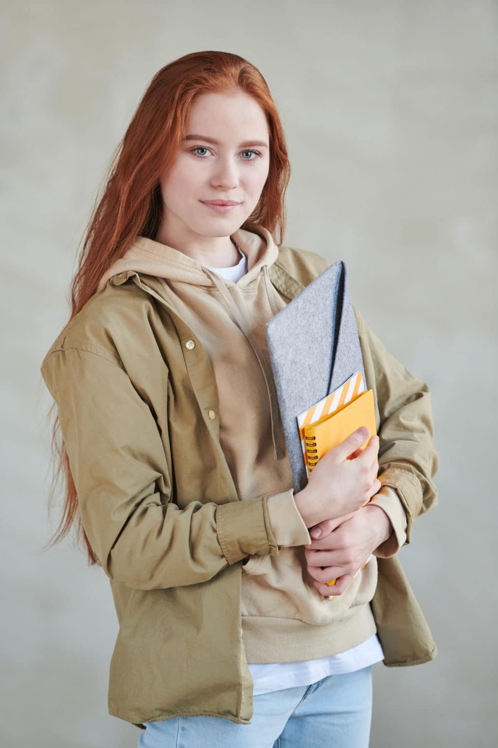 Student with red hair holding textbooks 1221245 1024x1536.jpg